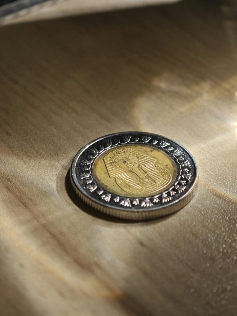 An Egyptian one pound coin placed on a wooden table surface