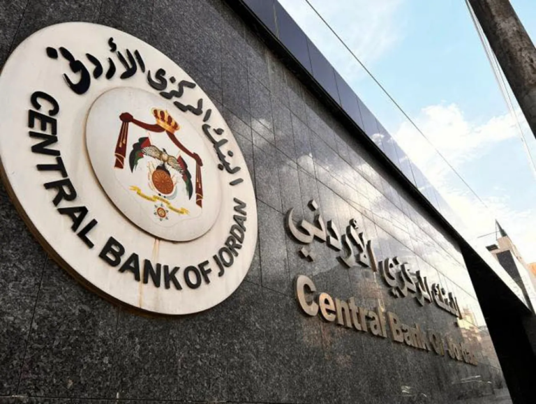The Central Bank of Jordan emblem, carrying the Hashemite coat of arms and the bank name in Arabic and English, mounted on the polished stone facade of the bank headquarters in Amman