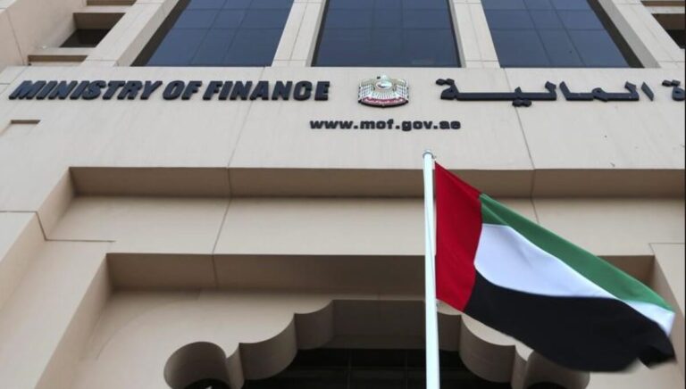 The facade of the UAE Ministry of Finance building with the national flag in front