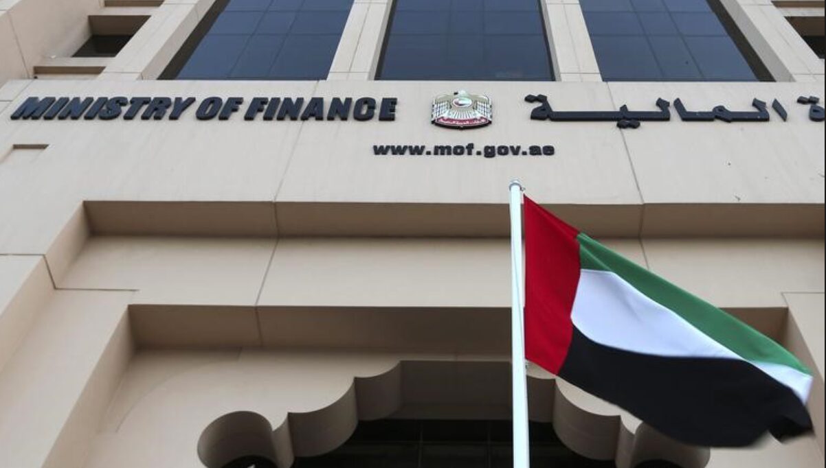 The facade of the UAE Ministry of Finance building with the national flag in front