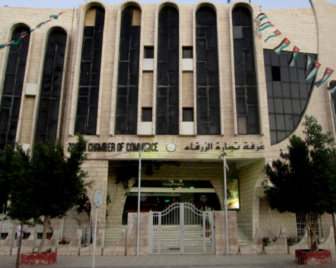 Exterior of the Zarqa Chamber of Commerce building in Zarqa, Jordan, decorated with Jordanian flags