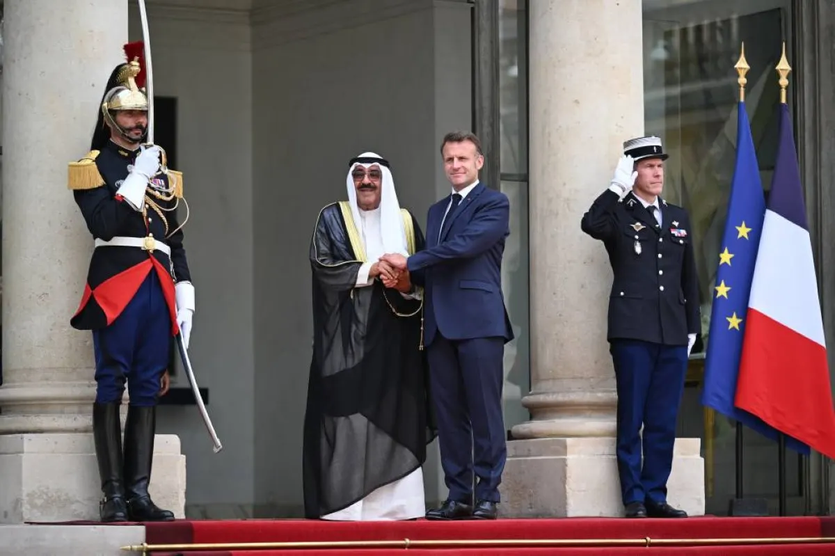 His Highness the Amir Sheikh Meshal Al-Ahmad Al-Jaber Al-Sabah and French President Emmanuel Macron shake hands on the steps of the Élysée Palace in Paris