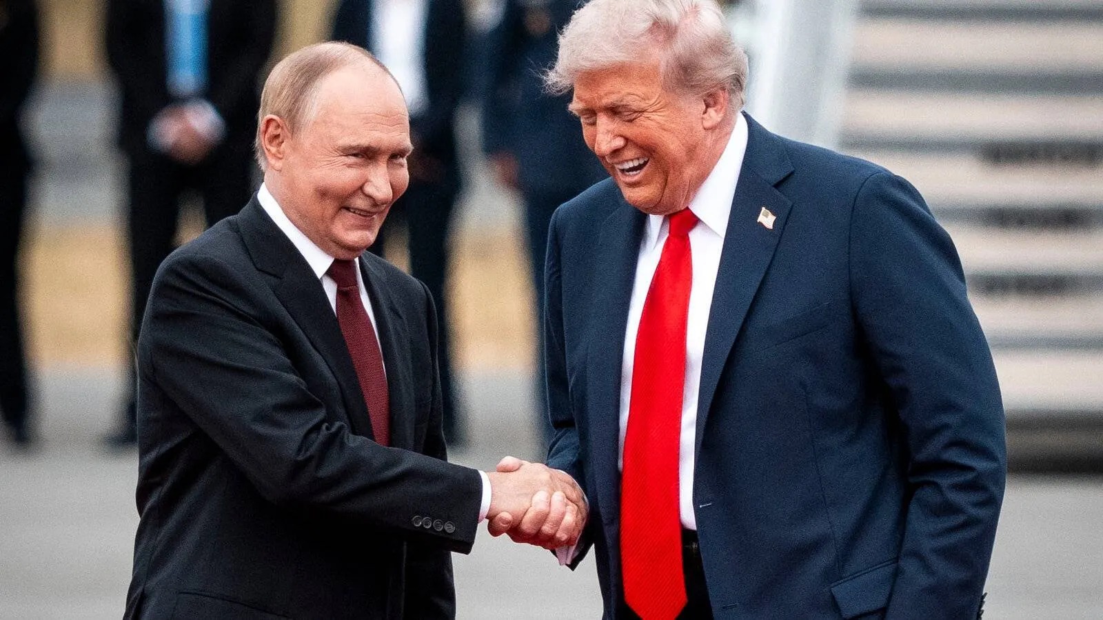 President Donald Trump and President Vladimir Putin shaking hands and smiling on an airport apron, archive photo
