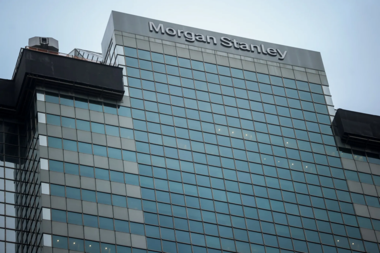 The Morgan Stanley name on top of a glass office tower under a grey sky, USA