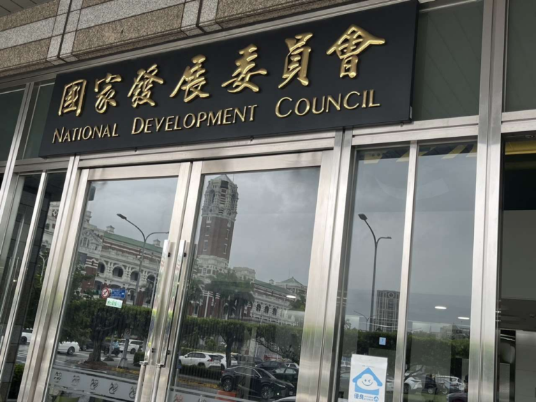 The entrance of the National Development Council in Taipei, with its name in Chinese and English above glass doors
