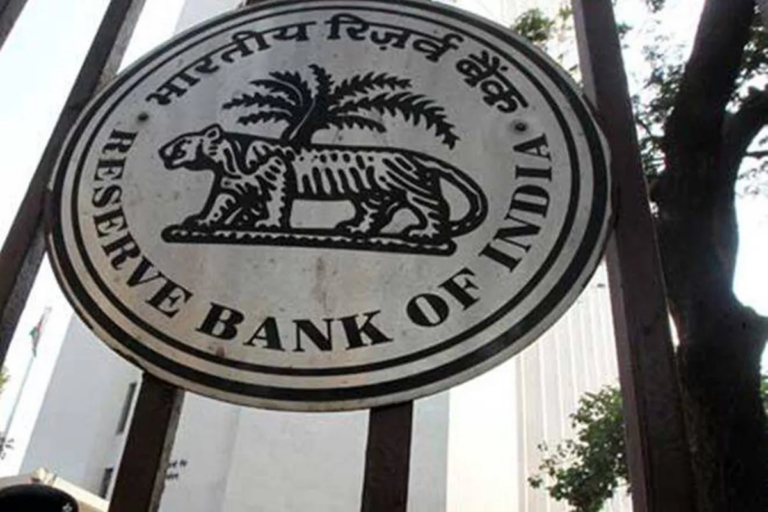 The Reserve Bank of India seal, with a tiger and palm tree and the bank's name in Hindi and English, on a gate outside a bank building