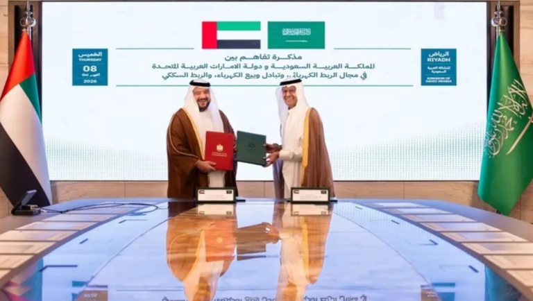 Saudi Minister of Energy Prince Abdulaziz bin Salman and UAE Minister of Investment Mohamed Hassan Alsuwaidi exchange signed folders in Riyadh on 8 October 2026, in front of a screen announcing the Saudi UAE memorandum on electricity interconnection, power exchange and sale, and rail connectivity